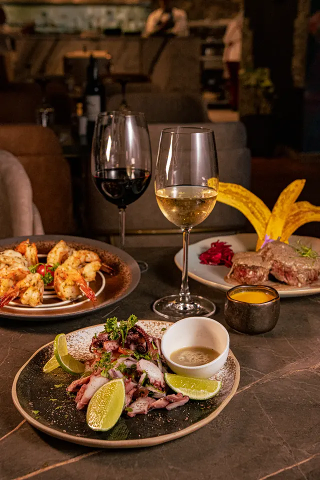Mesa con carnes, mariscos y vinos para compartir en Do Sul Restaurante